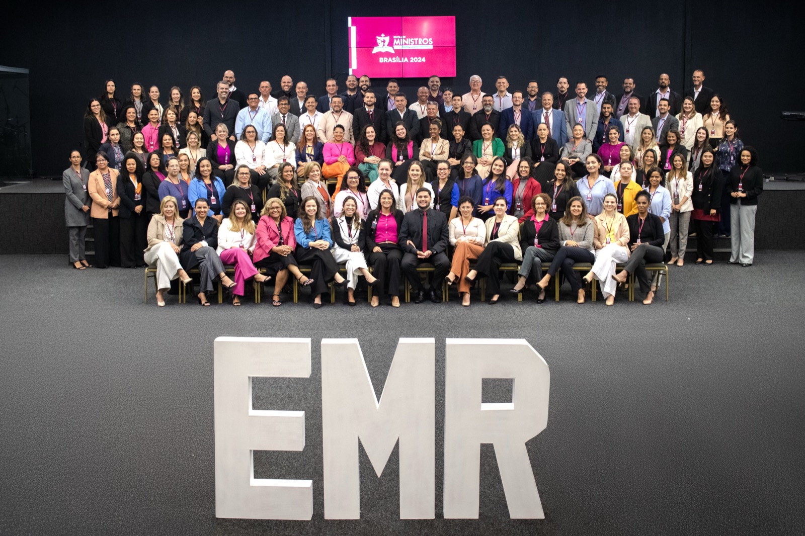 Large group photo of students behind the letters EMR