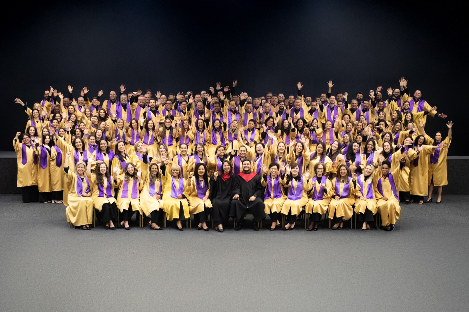 Graduating class in gold and purple gowns