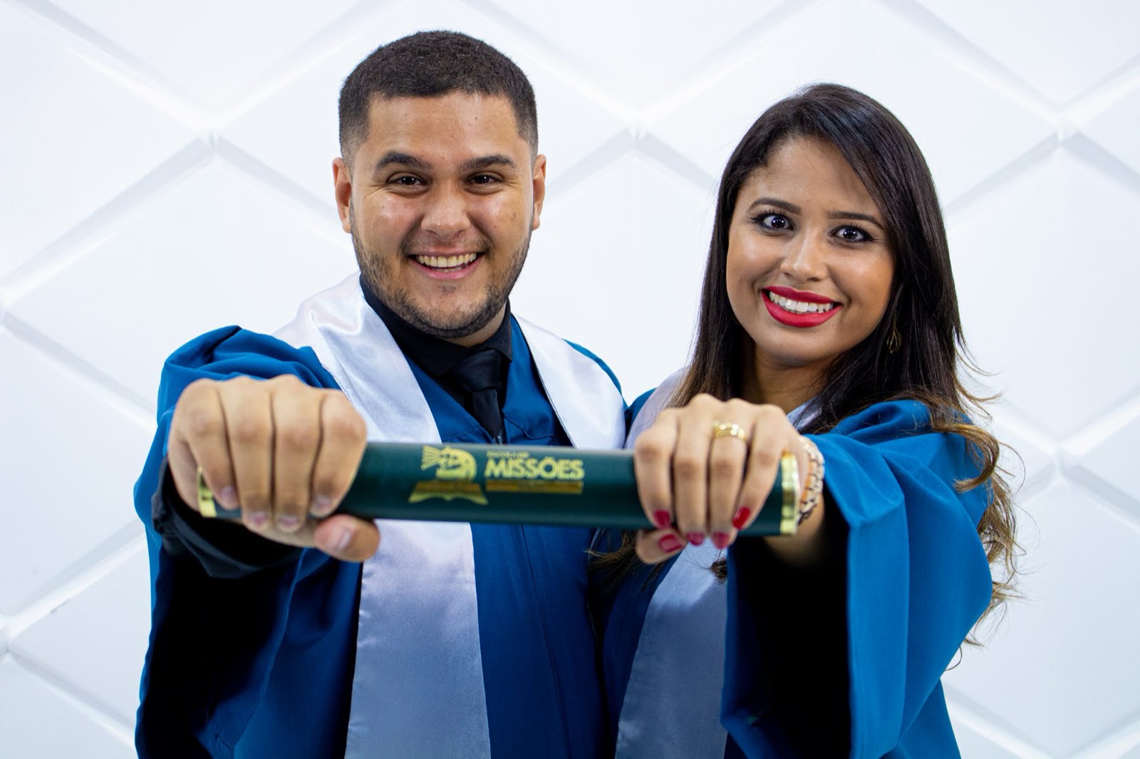 Daniel and Carla holding a diploma tube