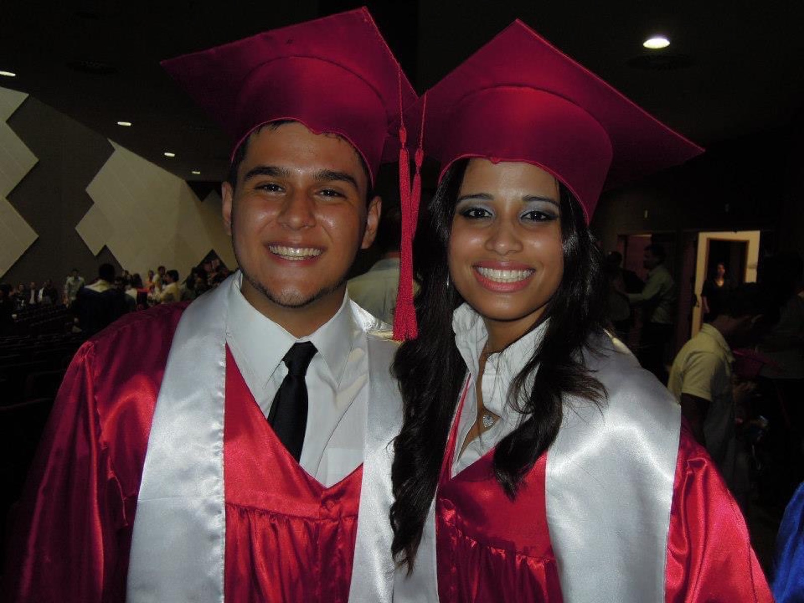 Daniel and Carla in red graduation gowns